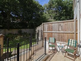 A garden area with chairs and a table at L'Ancresse Cottage in Lyme Regis