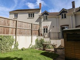 A garden with a table and fence at L'Ancresse Cottage Lyme Regis