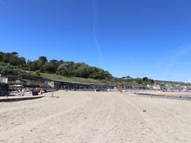 A beach with people and buildings in the background at L'Ancresse Cottage in Lyme Regis