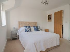 A bedroom with a bed and bedside table at L'Ancresse Cottage in Lyme Regis