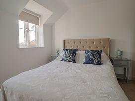 A bedroom with a bed and bedside tables at L'Ancresse Cottage in Lyme Regis