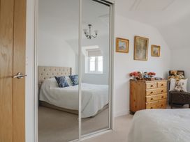 A bedroom with a bed, chest of drawers and decorative items at L'Ancresse Cottage in Lyme Regis