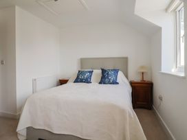 A bedroom with a bed and bedside table at L'Ancresse Cottage in Lyme Regis