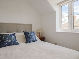 A bedroom with a bed and lamp at L'Ancresse Cottage in Lyme Regis