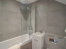A bathroom with a bathtub and shower at L'Ancresse Cottage in Lyme Regis