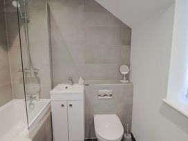 A bathroom with a bathtub and sink at L'Ancresse Cottage in Lyme Regis