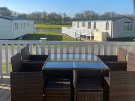 An outdoor seating area with a table and chairs at Primrose Valley Park - Pebbles Retreat, Primrose Valley