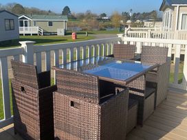 An outdoor terrace with a table and chairs at Primrose Valley Park - Pebbles Retreat in Primrose Valley