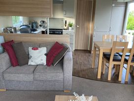 A living room with a sofa and dining area at Primrose Valley Park - Pebbles Retreat, Primrose Valley