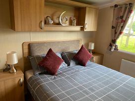 A bedroom with a bed and decorative items at Primrose Valley Park - Pebbles Retreat in Primrose Valley