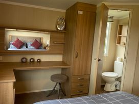 A bedroom with a desk and attached bathroom at Primrose Valley Park - Pebbles Retreat in Primrose Valley