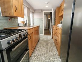 A kitchen with wooden cabinets and appliances at The Watch House in Weymouth