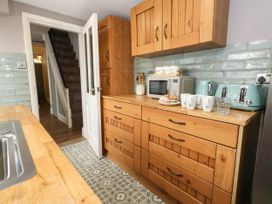A kitchen with wooden cabinets and appliances at The Watch House in Weymouth