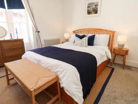 A bedroom with a wooden bed and bedside tables at The Watch House in Weymouth