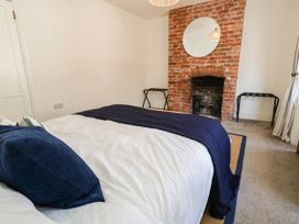 A bedroom with a bed and brick fireplace at The Watch House in Weymouth