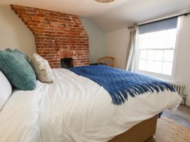 A bedroom with a brick wall and a bed at The Watch House in Weymouth