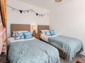 A bedroom with two beds, a lamp and bunting at The Watch House in Weymouth