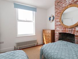 A bedroom with a window and a dresser at The Watch House in Weymouth