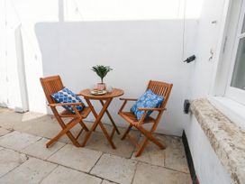 An outdoor seating area with two chairs and a small table at The Watch House in Weymouth