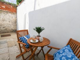 A table with mugs and a plant in a garden at The Watch House in Weymouth