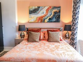 A bedroom with a bed and lamps at Smithy Cottage in Cemaes Bay