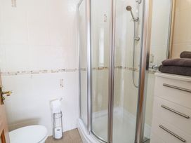 A bathroom with a shower and toilet at Smithy Cottage in Cemaes Bay