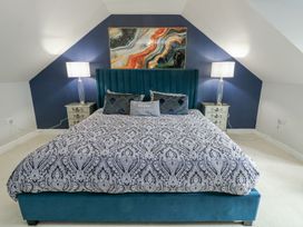 A bedroom with a large bed and bedside lamps at 1 The Old Smithy Cemaes Bay