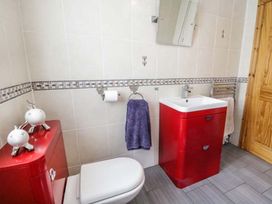 A bathroom with a sink, toilet, and towel rack at 1 The Old Smithy Cemaes Bay