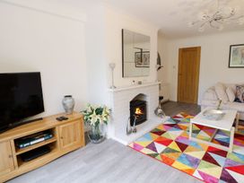 A living room with a television, sofa, and fireplace at Gwelfor in Cemaes Bay