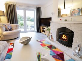 A living room with a fireplace and sofa at Gwelfor in Cemaes Bay