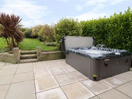 A garden with a hot tub and steps at Gwelfor in Cemaes Bay