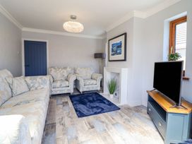 A living room with sofas and a television at Trefin Cemaes Bay