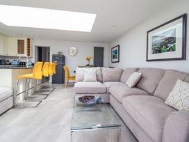 A living room with a sofa, coffee table and kitchen island at Trefin in Cemaes Bay