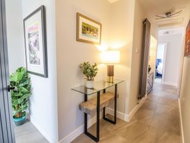 A hallway with a table and lamp at Trefin in Cemaes Bay