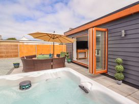 An outdoor area with a hot tub and seating at Trefin in Cemaes Bay