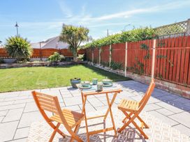 A garden with a table and chairs at Trefin in Cemaes Bay