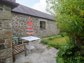 A garden area with a table and chairs at Swallow Cottage Helston