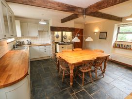 A kitchen with a table and chairs at Swallow Cottage in Helston