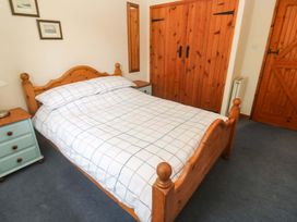 A bedroom with a bed and bedside table at Swallow Cottage in Helston