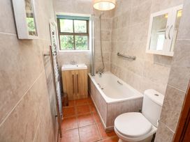 A bathroom with a bathtub, sink, and toilet at Swallow Cottage in Helston