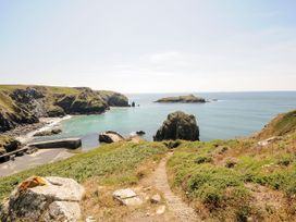 A coastal view with rocks and sea at Swallow Cottage in Mullion