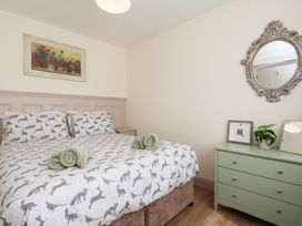 A bedroom with a bed and dresser at Badger Cottage in Driffield