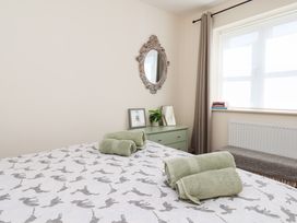 A bedroom with a bed and towels at Badger Cottage in Driffield