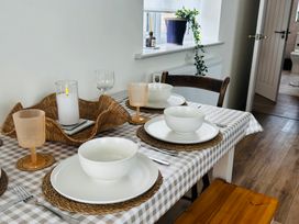 A dining table set with plates and bowls at Badger Cottage in Wold Newton