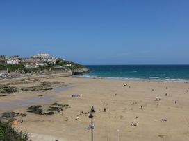A beach with people and buildings in the background at Studio Room No.2 Newquay