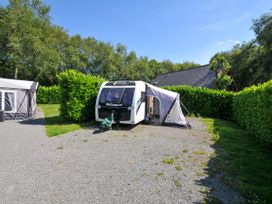 A caravan with an awning set up in a grassy area at Caravan in Dolton