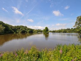 A lake surrounded by trees and grass at Caravan in Dolton