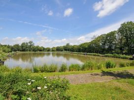 A pond with people fishing and greenery at Caravan in Dolton