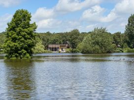 A building near a pond with trees and ducks at Caravan in Dolton