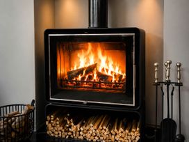 A fireplace with logs and a basket in a living room at Chowdene Lodge Estate